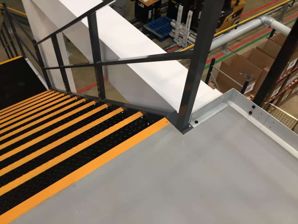 edge of mezzanine floor showing kick plate and top of staircase