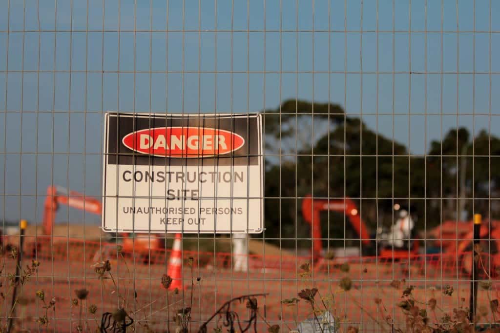 danger construction site sign behind fence