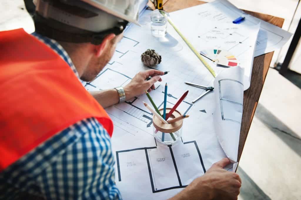construction person reviewing multiple printed drawings