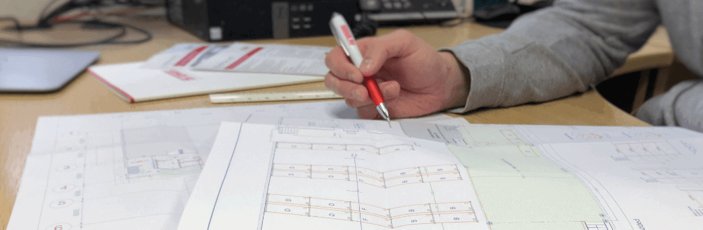 person working on printed autocad drawing