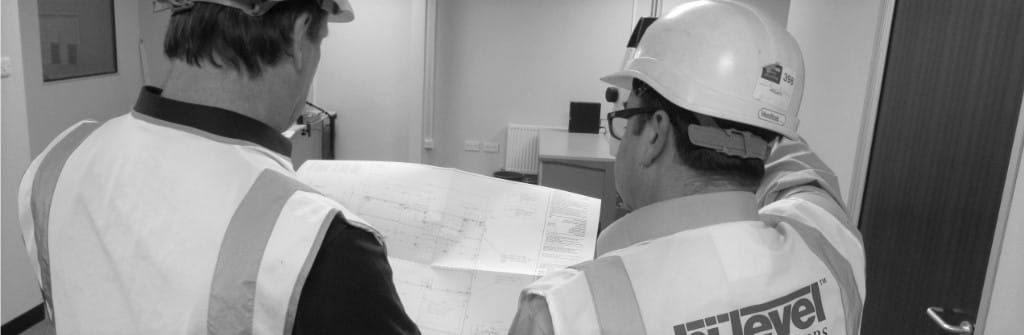 black and white image of two people discussing printed drawing of mezzanine