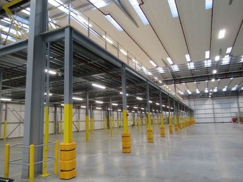 large mezzanine floor with column protectors in empty warehouse