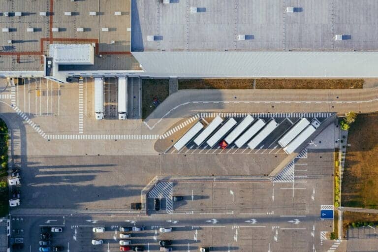 overhead shot of lorries parked outside warehouse