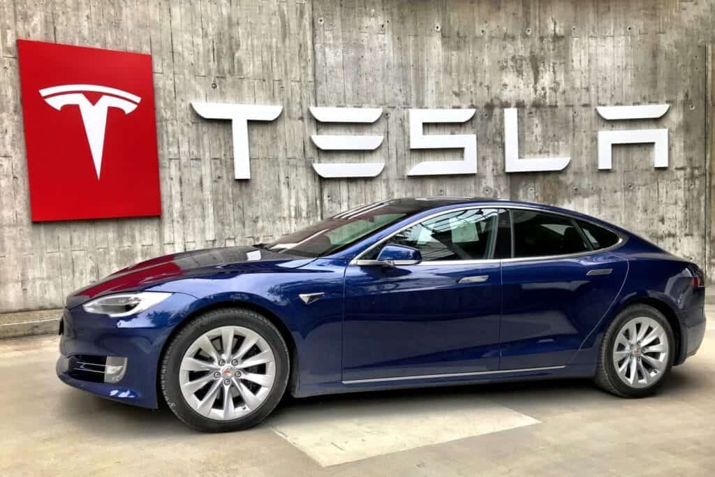 blue tesla car with tesla logo on wall