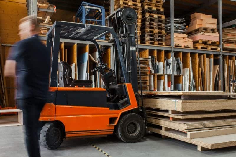 fork lift truck lifting pallet of wooden sheets